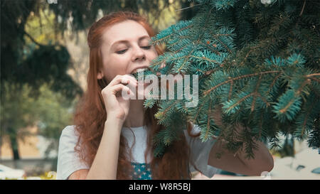 Smiling veggie girl is very hungry. Parody of vegetarian. Beautiful ginger woman on diet wants to eat very much. Funny redhead teenager wants to taste Stock Photo