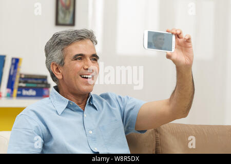 Senior man taking picture of himself with a mobile phone Stock Photo