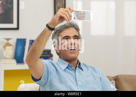 Senior man taking picture of himself with a mobile phone Stock Photo