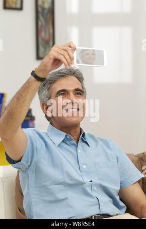 Senior man taking picture of himself with a mobile phone Stock Photo