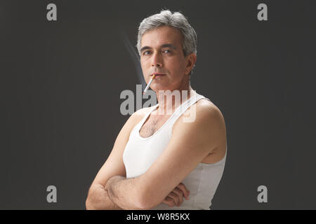 Senior man smoking cigarette Stock Photo