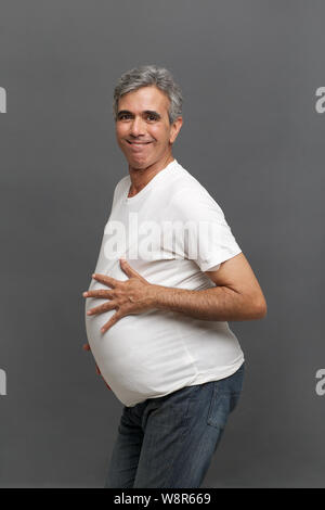 Senior man pretending to be a pregnant woman Stock Photo