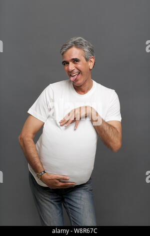 Senior man pretending to be a pregnant woman Stock Photo