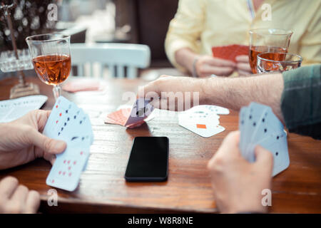 Man reaching his hand while taking card from the table Stock Photo