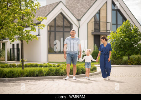 Parents and daughter walking in the cottage city at the weekend Stock Photo