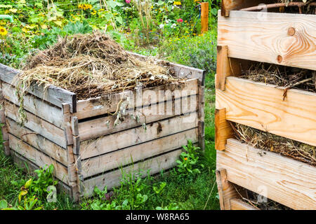 Wooden composter, compost heap garden, dry plant and other bio waste on pile Stock Photo