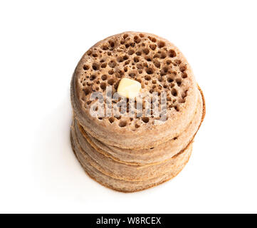 Stack  of wholemeal crumpets isolated on white background Stock Photo