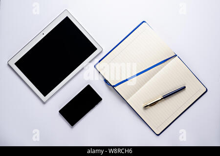 Business design flat lay, notepad with pen, smartphone and tablet top view Stock Photo