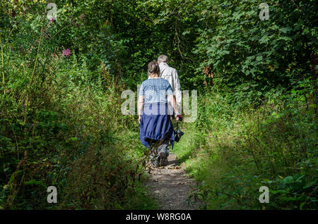 A couple on a walk down a trail through woods in the South Staffordshire countryside. Stock Photo