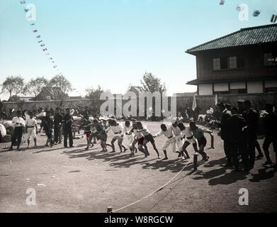 [ 1900s Japan - Japanese School Life ] —   Elementary school students participate in their school's sports day.  This image is part of 'The School Life of Young Japan' (No 17), a series published by Japanese photographer Kozaburo Tamamura in the early 1900s (late Meiji).  20th century vintage glass slide. Stock Photo