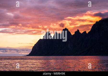 View over Oksen Mountain range devils jaw  at Ersfjord in colorful impressive sunset, Senja, Norway Stock Photo