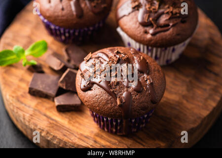Double chocolate muffins covered with melted chocolate on a wooden background Stock Photo