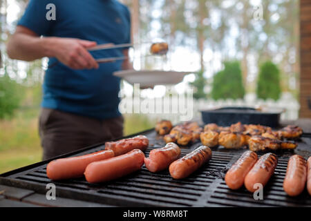 Delicious sausages and chicken legs are fried on bbq Stock Photo