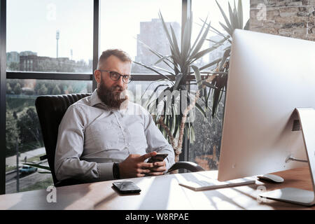 Portrait Of Businessman At Office Desk Using Computer. Stock Photo