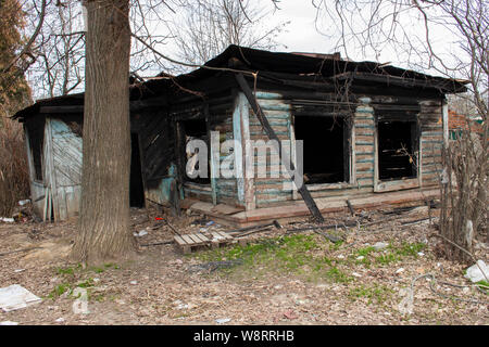 Burnt wooden country house. Country residence after a fire. Black charred window walls. Misfortune, danger, accident Stock Photo