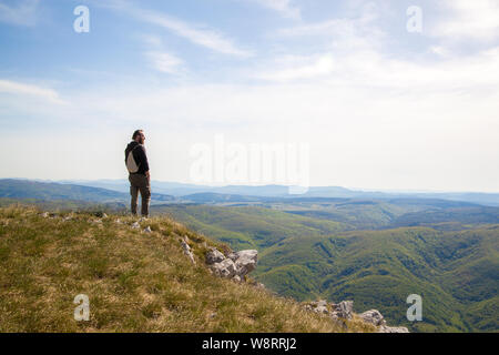 A man standing on the edge of a cliff and looking down on a Vipava valley Stock Photo