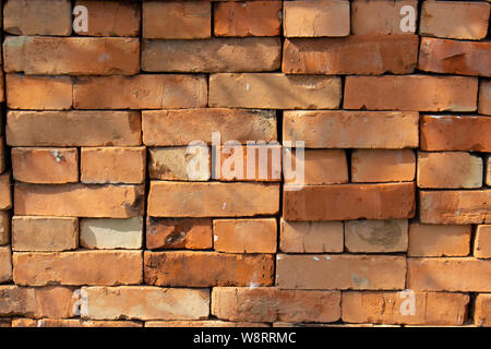 Red brick stack, background texture pattern. A pile of bricks material for construction. Red sandstone silicate brick Stock Photo