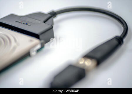 hdd 2.5 hard drive disk connected to smartphone via sata usb cable closeup overhead view Stock Photo