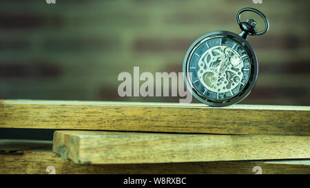 Pocket watch on stacked lumber in morning. At 8 am. o'clock. Concept of starting work today. Stock Photo