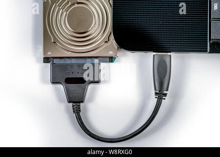 hdd 2.5 internal hard drive disk connected to laptop via sata usb cable closeup view Stock Photo