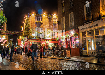 Dublin, Ireland - December 06, 2018: Crowd of people outside the famous Temple Bar pub in central Dublin at night Stock Photo