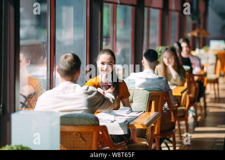 A young couple drinking wine in a restaurant near the window. Stock Photo