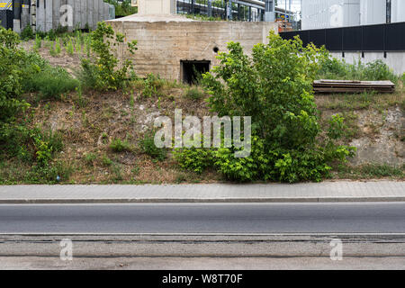 Abandoned reinforced concrete bunker from World War II on the side of the road in city of Warsaw in Poland. Stock Photo