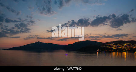 Dusk and the sun sets over the beautiful entrance to the harbour of Kalkan in Turkey, a popular tourist destination. Stock Photo