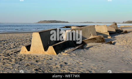Concrete blocks used to form a breakwater at the south end of Tybee Island Georgia, stored on a beach. Stock Photo