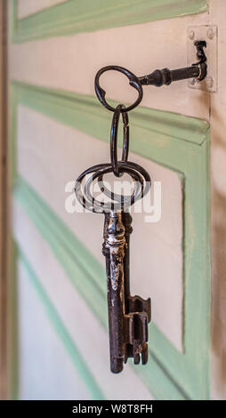 Old keys hanging out of keyhole in old French door