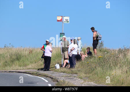 People waiting at a bus stop Stock Photo