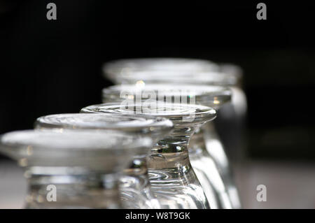close up row of glasses turned upside down on a table Stock Photo