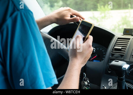 Man using smartphone while driving the car - transportation and vehicle concept with icon social media send email wifi chat read email Stock Photo