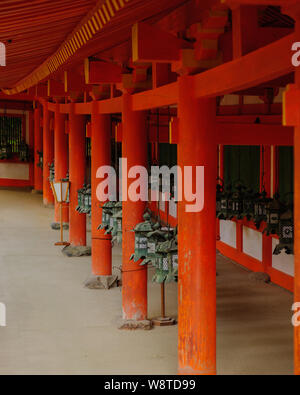 Group of traditional bronze lanterns hanging from the roof of shrine main building in Naras Kasuga Taisha delivering a pattern, Japan November 2018 Stock Photo