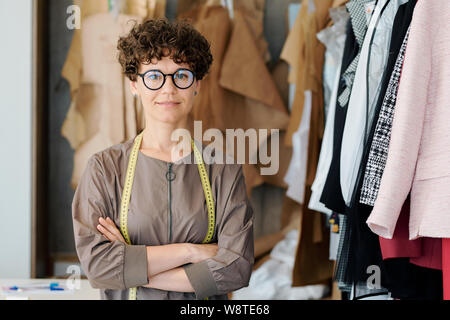 Young elegant woman in eyeglasses looking at you in fashion studio Stock Photo