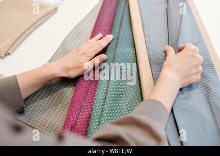 Female designer looking through textiles for new collection Stock Photo