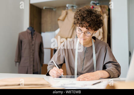 Young female designer concentrating on looking though digital models Stock Photo