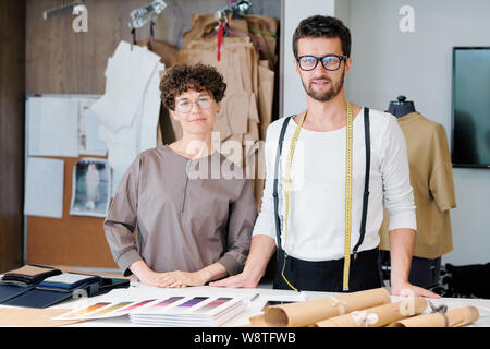 Two young confident designers of new fashion collection doing their usual work Stock Photo