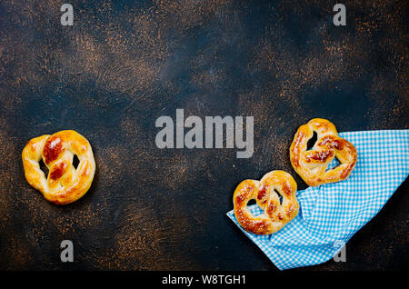 baked pretzels with blue napkin on dark kitchen table, Preparation of baked goods, bakery concept, Rustic background for Oktoberfest with letters Stock Photo