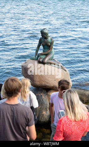 Copenhagen holiday; tourists looking at the Little Mermaid statue, Copenhagen Denmark Scandinavia Europe Stock Photo