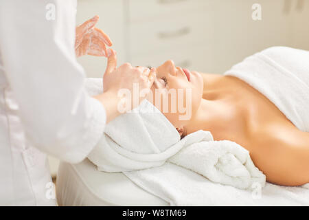 Beautician makes facial massage to the girl Stock Photo