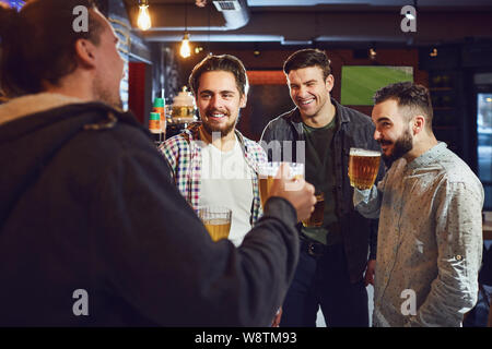 Friends talk, drink beer in a bar. Stock Photo