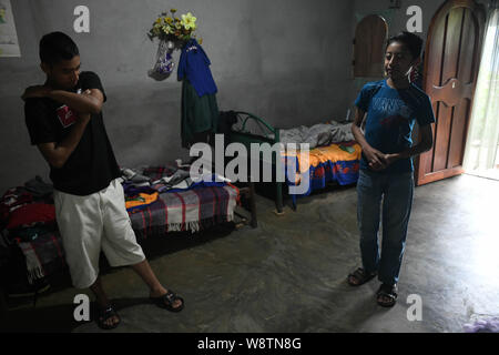 August 8, 2019, La Reforma, San Marcos, Guatemala: Eight days after being deported from the U.S., Lisardo Perez, 19,  stands by his  ill brother Edgar Giovani, 14, at their house in the Canton La Palma neighborhood, in La Reforma, Guatemala.Â After 8 years of falling coffee prices, 4 off a steady job from his father, and 3 years watching his younger brother Edgar Giovani suffer a debilitatingÂ illness that left the family in medical debt, they put all their hope in Lisardoâ€” taking an $8000 loan against their house to pay a smuggler to take him to the U.S., where they hoped heâ€™d make enough Stock Photo