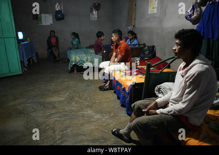 August 8, 2019, La Reforma, San Marcos, Guatemala: Eight days after being deported from the U.S., Lizardo Perez, 19, sits among his family in their one-room house in the Canton La Palma neighborhood of La Reforma, Guatemala.  â€œHe returned very pretty,â€ his mother said, seeing that his permanent malnourishment was gone. â€œIn 45 days he went from 4 to 10.â€  Lisardo spent two grueling months traveling through Mexico and the south Texas desert. He and 19 other migrants were detained near Corpus Christi, Texas and he spent 45 days in a detention center before being deported back to an area w Stock Photo