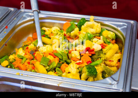 Steamed vegetables in metal tray, dining room Stock Photo