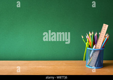 Pencil in basket on wood table with Blackboard (Chalk Board) as background  with copy space. Education and Back to school concept. Stock Photo