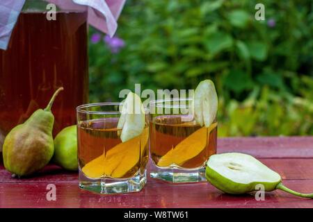 Homemade Fermented Raw Kombucha Tea with Pears, Summer Healthy Detox Drink in jar and two glass, Horizontal Orientation Stock Photo