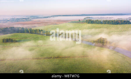 Summer nature landscape aerial panorama. Morning fog over river, meadow and forest. Nature sunlight scene at foggy sunrise. Belarus, Europe Stock Photo