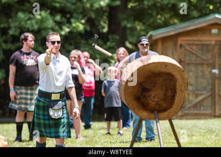 A man throws a hatchet at a wood target in an axe throwing exhibition  at the Blairsville Scottish Highland Games on June 9, 2018 in Blairsville, GA. Stock Photo