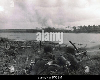 Waffen SS Troops give covering fire with a Light MG at a river crossing on the Russian Front 1941 Stock Photo